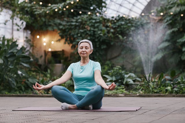 A woman meditating in an indoor garden