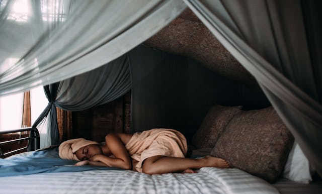 A woman sleeping deeply in a luxury bed